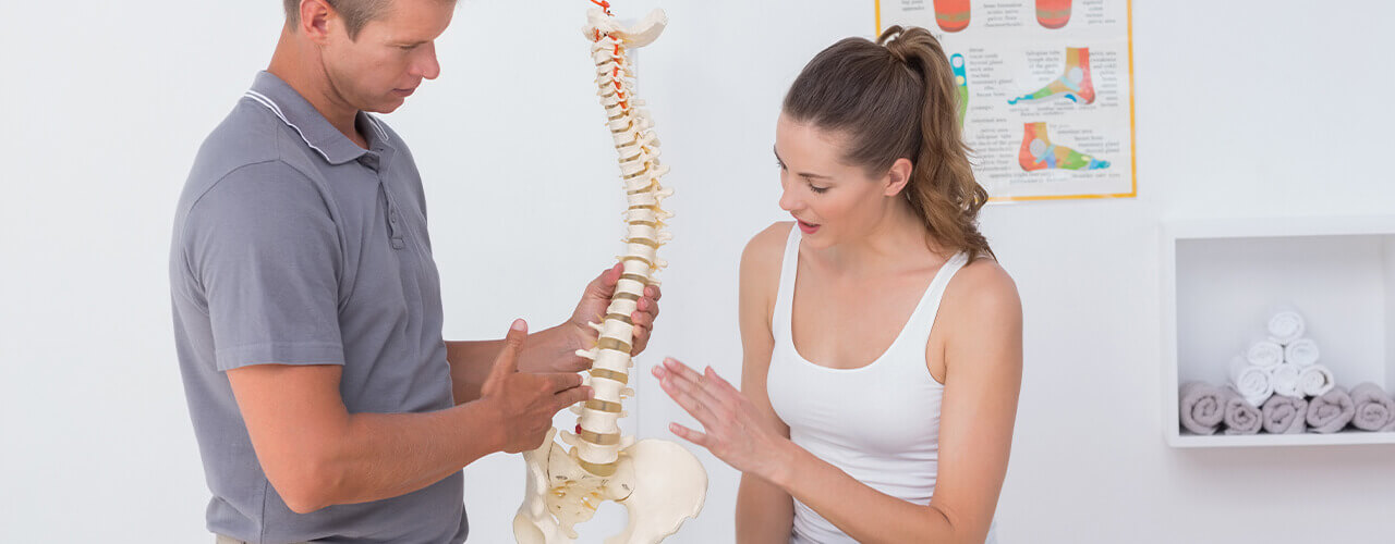 A therapist showing a patient herniated disc anatomy